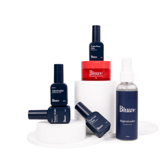 Vários produtos da Bluwe dispostos em fundo branco, são eles: Higienizador, Preparadores, Capa Base Flex, Gel Banho de Fibra e Top Coat Clear.